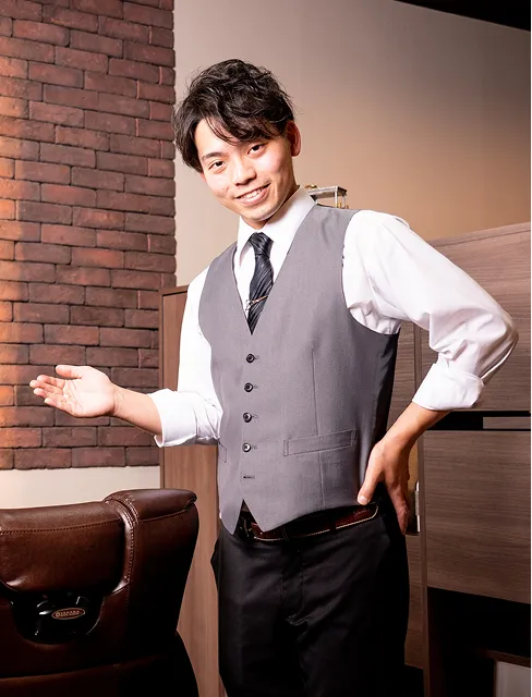 札幌の高級理容室で施術席に案内する笑顔の理容師