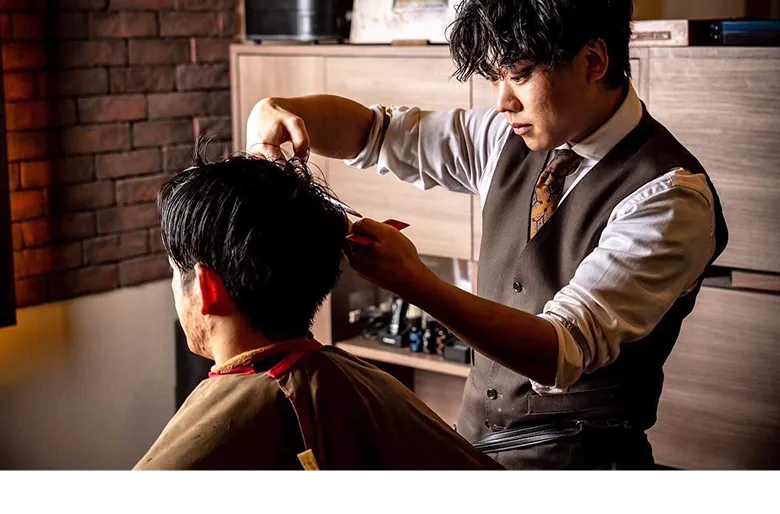 札幌の高級理容室で丁寧にヘアカットを施す理容師の施術風景